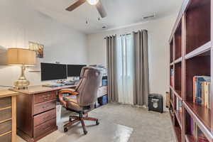 Office space with light carpet and ceiling fan