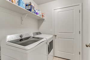 Laundry area with washer and dryer and light tile floors