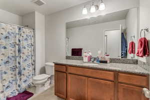 Bathroom with tile flooring, vanity, and toilet