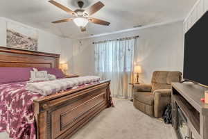 Carpeted bedroom featuring ceiling fan