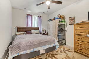 Bedroom with ceiling fan and light colored carpet