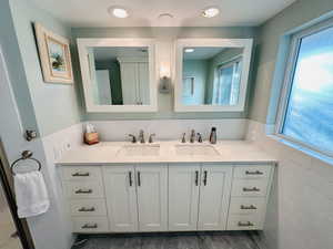 Master Bathroom featuring a large vanity, dual sinks, and tile walls