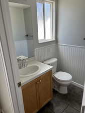 Bathroom featuring tile floors, vanity, and toilet