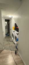 Laundry area with a textured ceiling, light hardwood / wood-style floors, and washing machine and clothes dryer