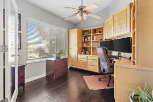 Office area with ceiling fan, vaulted ceiling, and dark wood-type flooring