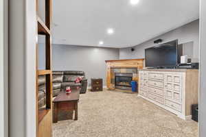 Carpeted living room with a tiled fireplace