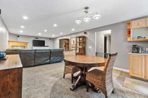 Dining room featuring light colored carpet and a textured ceiling