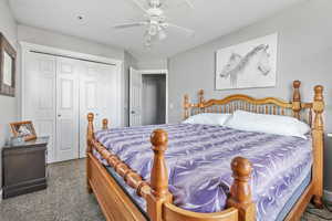 Carpeted bedroom with a closet and ceiling fan