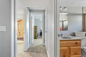 Bathroom with vanity, toilet, and a textured ceiling