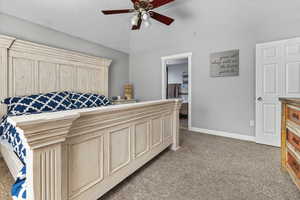 Bedroom featuring ensuite bath, ceiling fan, and carpet floors