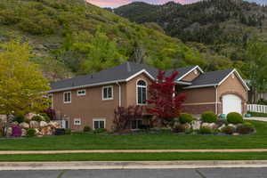 View of front of property with a garage and a lawn