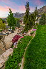 Yard at dusk featuring a patio and a mountain view