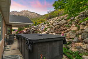 Exterior space featuring a mountain view, a hot tub, and a patio