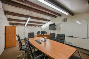 Office space featuring carpet and lofted ceiling with beams