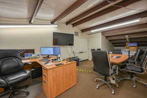 Carpeted office featuring lofted ceiling with beams