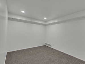 Unfurnished room featuring dark colored carpet