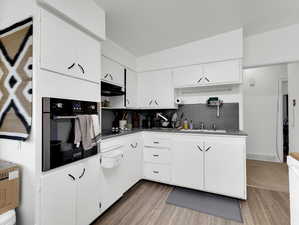 Kitchen featuring white cabinetry, tasteful backsplash, and stainless steel oven