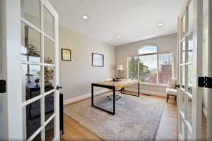 Home office featuring french doors and wood-type flooring