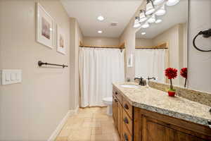 Bathroom featuring tile flooring, vanity, and toilet