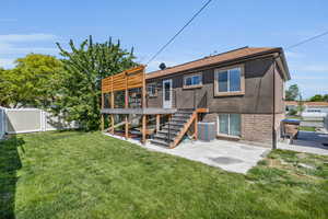 Back of house with a yard, central air condition unit, a patio, and a wooden deck