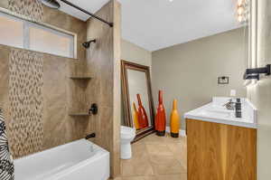 Full bathroom featuring tile floors, shower / bath combo with shower curtain, toilet, and vanity