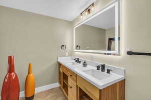 Bathroom with vanity with extensive cabinet space, dual sinks, and tile floors