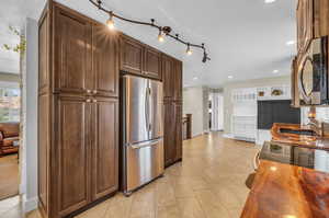 Kitchen with appliances with stainless steel finishes, sink, track lighting, and a textured ceiling