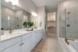 Bathroom with dual vanity, tile floors, and independent shower and bath