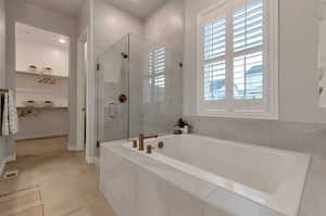 Bathroom featuring tile floors, a wealth of natural light, and shower with separate bathtub