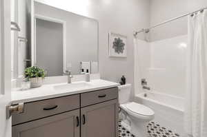 Full bathroom featuring tile floors, shower / bath combo with shower curtain, toilet, and large vanity