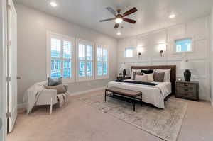 Carpeted bedroom featuring ceiling fan