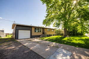 Ranch-style house featuring a front lawn and a garage