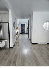 Interior space featuring hardwood / wood-style flooring, stainless steel refrigerator, and gray cabinets