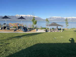 View of yard with a playground, a water and mountain view, and a gazebo