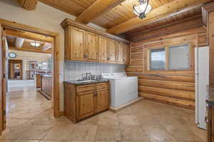 Laundry area/ mud room with cabinets, rustic walls, light tile floors, and wood ceiling