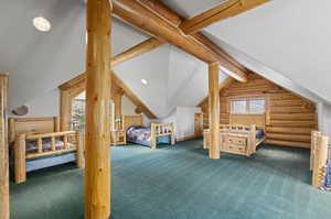 Carpeted loft bedroom featuring lofted ceiling with beams and rustic walls