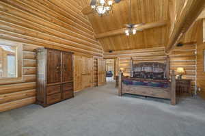 Primary bedroom with carpet flooring, rustic walls, and wood ceiling