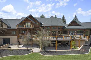 Back of property with a patio area, a wooden deck, and a yard