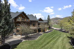 View of yard with a deck with mountain view, central air condition unit, a balcony, and a patio