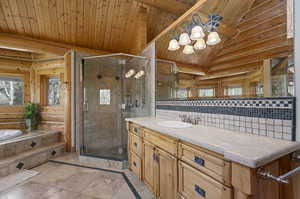 Primary bathroom with lofted ceiling, rustic walls, and wood ceiling