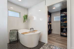 Bathroom with a tub and wood-type flooring