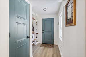 Doorway to outside featuring light hardwood / wood-style flooring and a textured ceiling