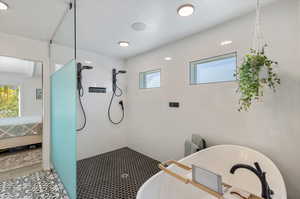 Bathroom with tile flooring and shower with separate bathtub