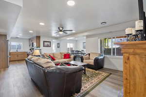 Apartment Living room with sink, ceiling fan, a textured ceiling, and light hardwood / wood-style flooring