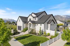 View of front of house featuring a garage, a mountain view, and a front lawn