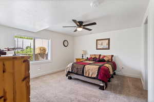 Apartment Carpeted bedroom with a textured ceiling and ceiling fan