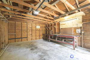 Garage featuring a garage door opener, wooden walls, and a workshop area