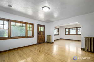 Spare room with radiator and light wood-type flooring