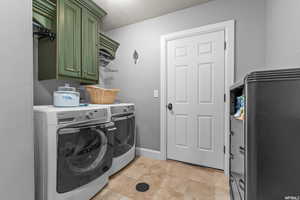 Laundry room with cabinets, light tile floors, and separate washer and dryer