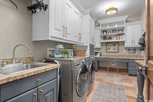 Laundry area with cabinets, hookup for a washing machine, independent washer and dryer, sink, and light tile flooring